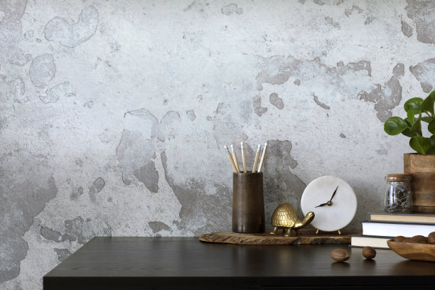 极简主义的工业家庭办公室内部组成，复制空间，黑色的桌子，花盆里的植物，时钟，金色的乌龟，灰色的混凝土墙和办公配件。家居装饰。模板。图片下载