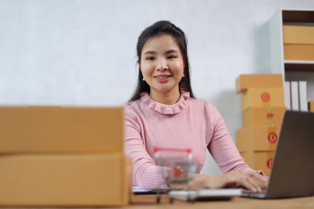 在家里用笔记本电脑工作的小企业主(女)正在查看网上订单，准备发货。图片下载