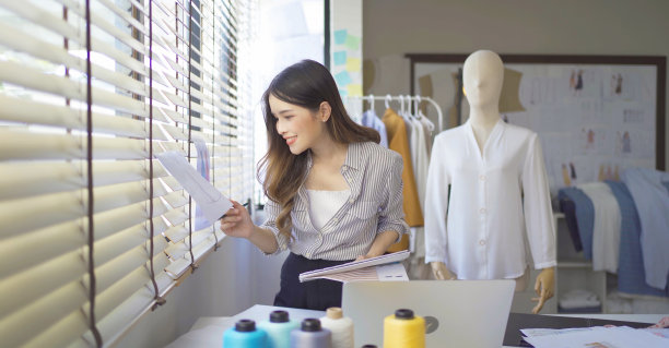 自由设计师，裁缝，造型师艺术家亚洲女性，泰国人在家里或房子在线上工作的时装设计衣服和服装衬衫。人们的生活方式。创新业务。图片下载
