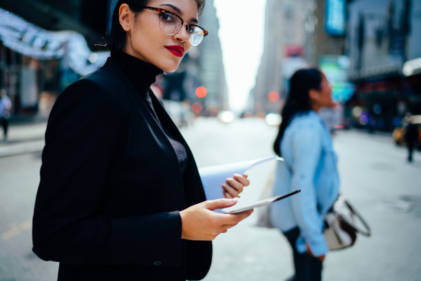 优雅的女商人穿过城市街道图片下载
