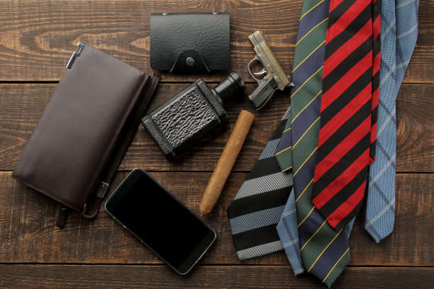 男人的配件。男人的风格。领带，智能手机，香水，钱包，名片在一个棕色的木制背景。平的。图片下载