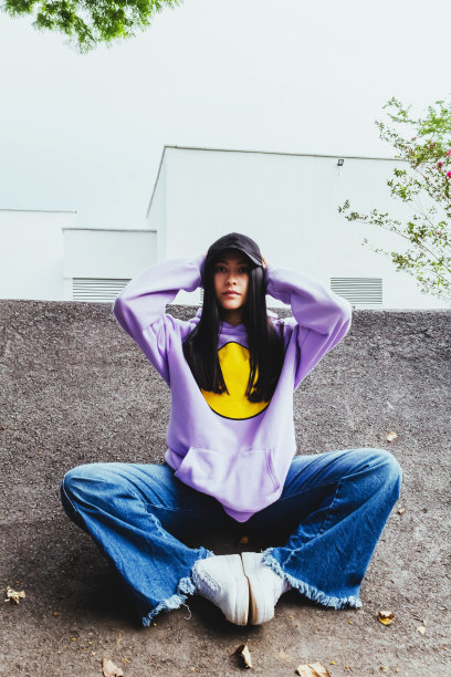 美丽的少女在运动衫和帽子坐在城市的城市风格图片下载