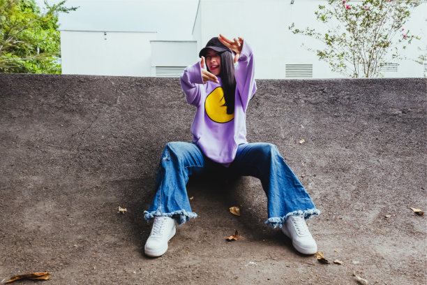 美丽的少女在运动衫和帽子坐在城市的城市风格图片下载