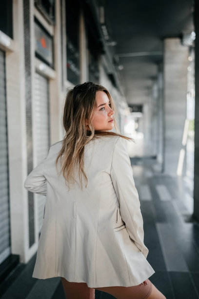 漂亮的女人走在现代化的城市街道上图片下载