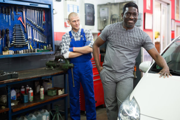 满意的男性客户的肖像与机械师站在她的汽车修理后，在车间图片下载