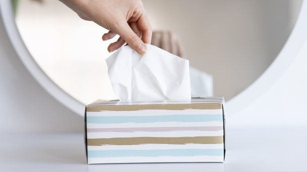 妇女用手从纸巾盒中挑选餐巾纸图片下载