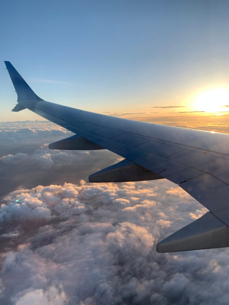 日出时飞机在云层上飞行的美丽照片图片下载