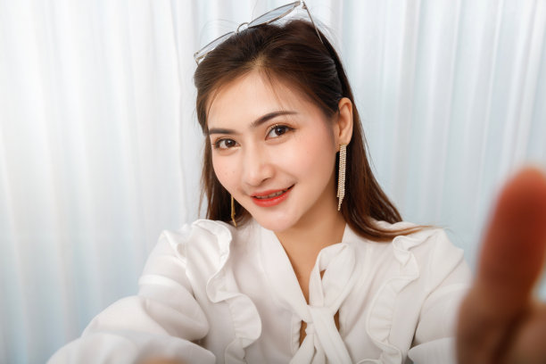 年轻的亚洲女性旅行博主一边用智能手机自拍一边录制vlog视频直播。博客和视频博主是社交媒体概念上的网络影响者。图片下载