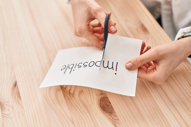 年轻的白人妇女在办公室剪不可思议的字图片下载