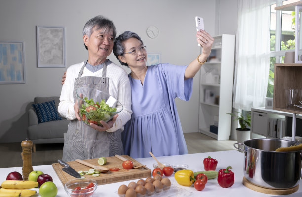 快乐的亚洲老夫妇在做饭和自拍时看起来很快乐。图片下载