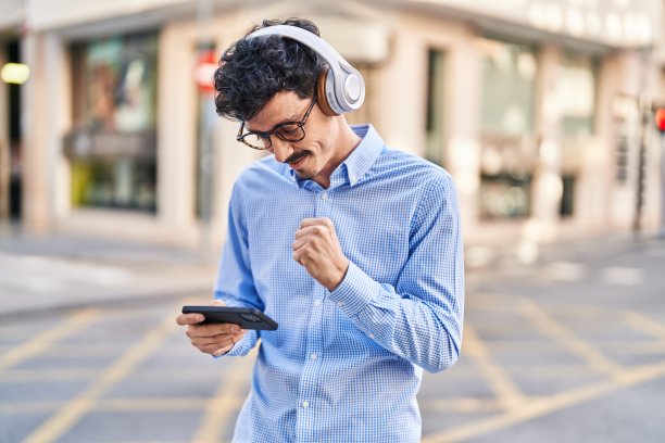 年轻的白人男子微笑着自信地在街上玩电子游戏图片下载