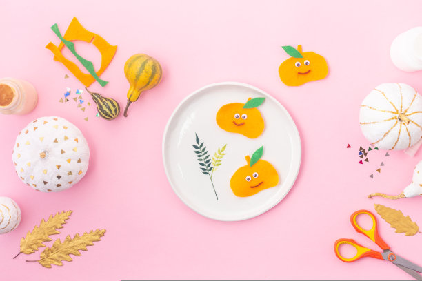 给孩子们的秋季概念工艺品，有眼睛的感觉南瓜和装饰南瓜白色和金色的叶子图片下载