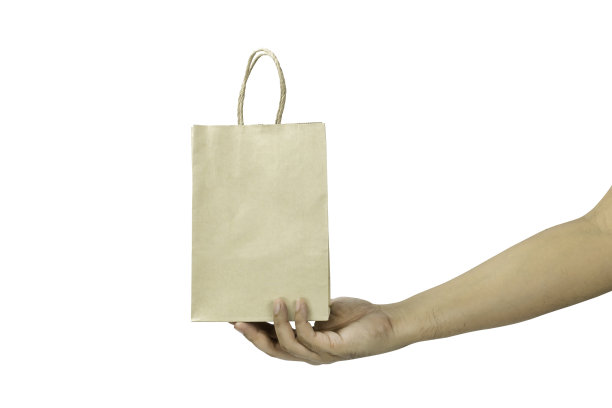 手拿一个纸袋孤立在一个白色背景与裁剪路径。图片下载