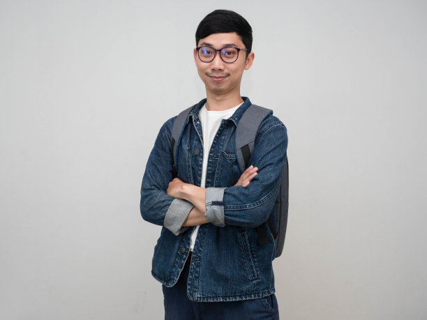 英俊的亚洲男子牛仔裤衬衫戴眼镜双臂交叉自信地看着你孤立的工作室拍摄图片下载
