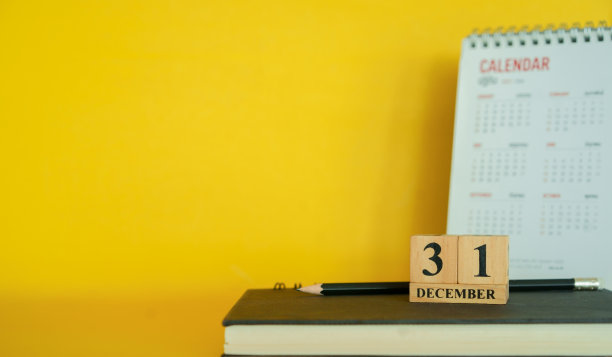 关闭了12月31日的立方体形状的木头在书的黄色背景为最后一年倒计时的一天的概念图片下载