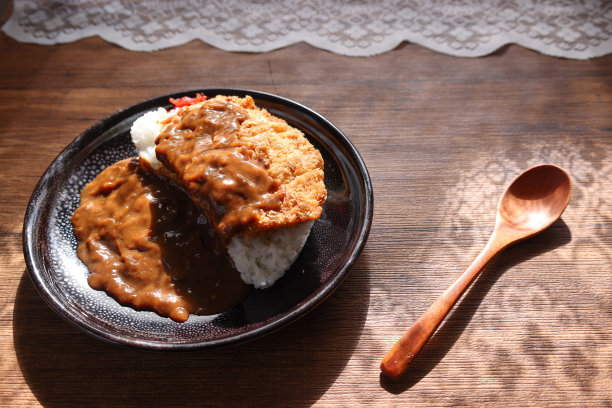 咖喱猪肉片盛在木桌上的黑色盘子里。图片下载