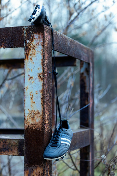 足球鞋挂在金属结构上。图片下载