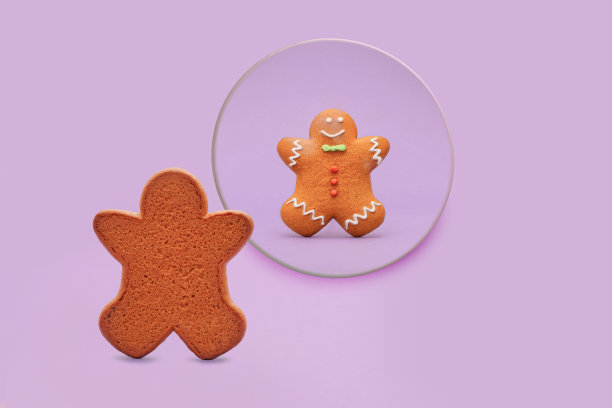 一个有趣又可爱的概念。一个有着丰富多彩的细节的饼干人看着一面圆镜。从前面和后面的数字。一个有心理学意义的概念。柔和的背景。图片下载