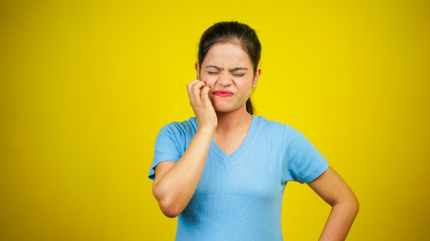 年轻女子挠脸或脸颊，隔离在黄色背景上。过敏反应引起的令人讨厌的瘙痒和皮疹图片下载