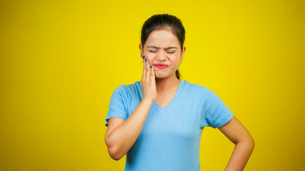 年轻女子挠脸或脸颊，隔离在黄色背景上。过敏反应引起的令人讨厌的瘙痒和皮疹图片下载