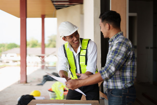 建筑师团队为建筑规划绘制蓝图，工程师绘制建筑项目草图，绿色能源概念图片下载