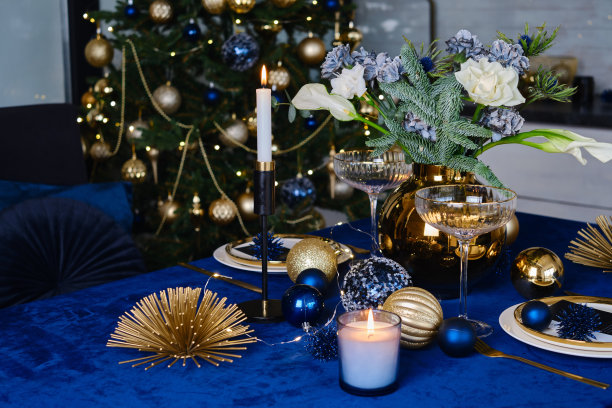 摆满鲜花和蜡烛的圣诞餐桌。新年和圣诞节的气氛。美丽快乐的灯光。举办庆祝晚宴图片下载