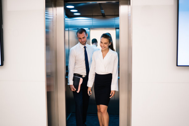 两个同事从办公室的电梯里走出来图片下载