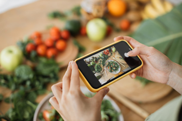 女人用手机拍食物，午餐或晚餐。图片下载