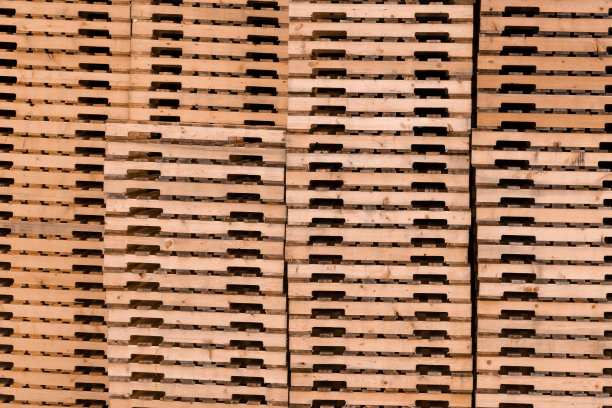 运输托盘。木制墙壁。托盘堆叠图片下载