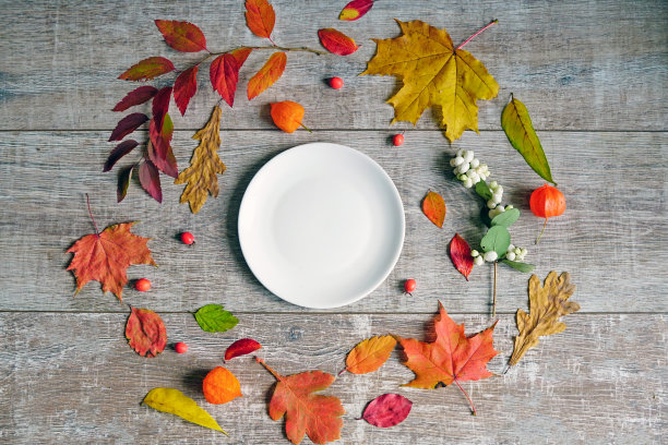 秋叶放在桌子上，围着一个白色的盘子。图片下载
