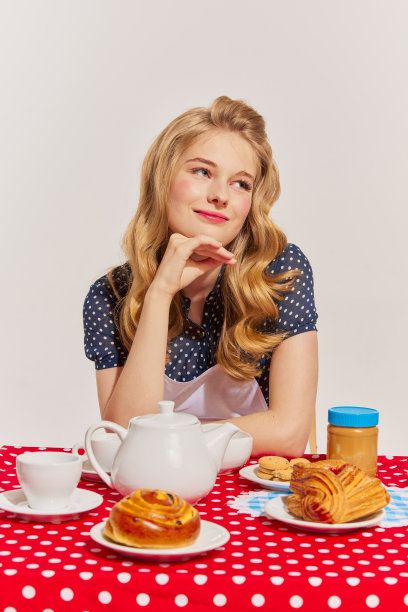 画像美丽的年轻女子坐在餐桌和吃早餐在灰色的背景图片下载