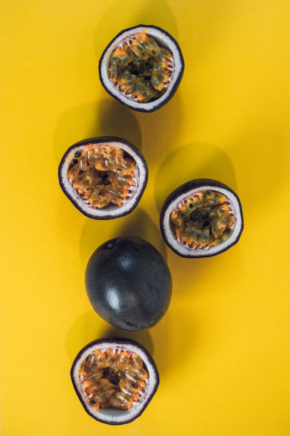 西番莲切片。黄色背景上的新鲜百香果。图片下载