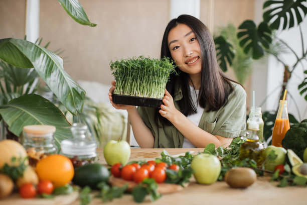 亚洲女性博主在智能手机上录制视频课程，介绍如何制作健康沙拉的食谱图片下载
