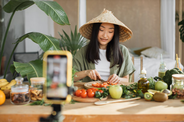 年轻的亚洲女博主或内容创造者切西红柿准备素食沙拉图片下载