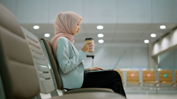 穆斯林女商人在机场用笔记本电脑工作图片下载