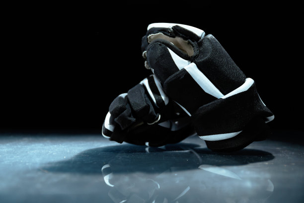 靠近冰球手套躺在反射表面。图片下载