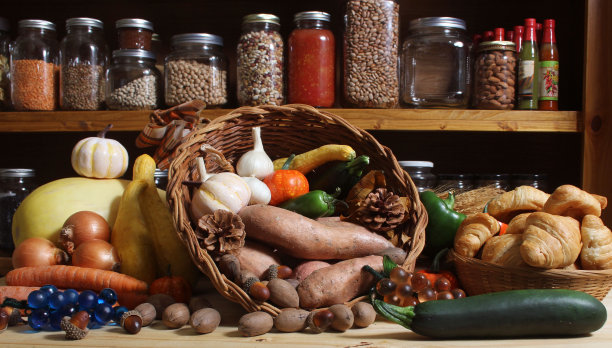 乡村厨房里的新鲜蔬菜和面包篮子，背景是一罐罐的干粮图片下载