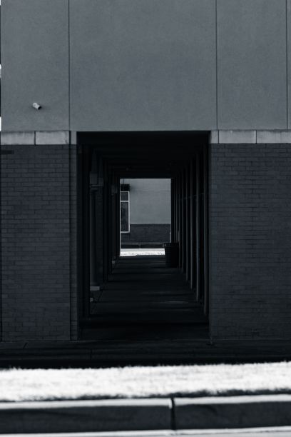 垂直拍摄现代建筑下从街道一侧到另一侧的黑暗通道图片下载