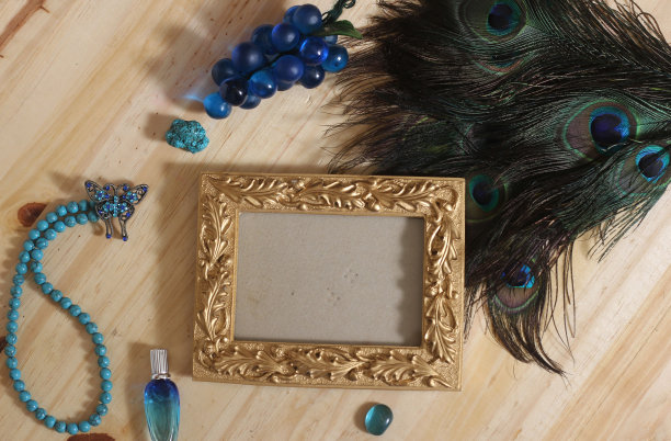 蓝色珠宝孔雀羽毛配金画框木桌图片下载
