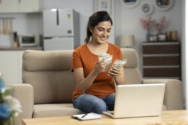 印度年轻女子在家里数钱，股票照片图片下载