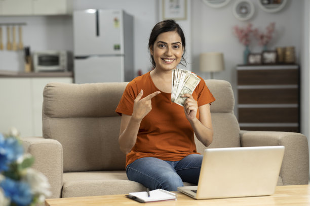 印度年轻女子在家里数钱，股票照片图片下载