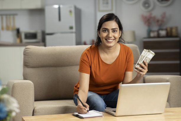 印度年轻女子在家里数钱，股票照片图片下载