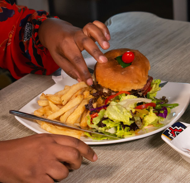 吃美味汉堡配薯条和沙拉的人图片下载