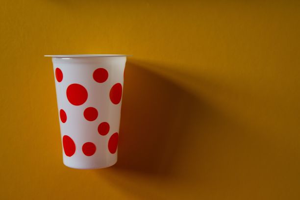 橙色背景下的圆点塑料杯的美丽照片图片下载