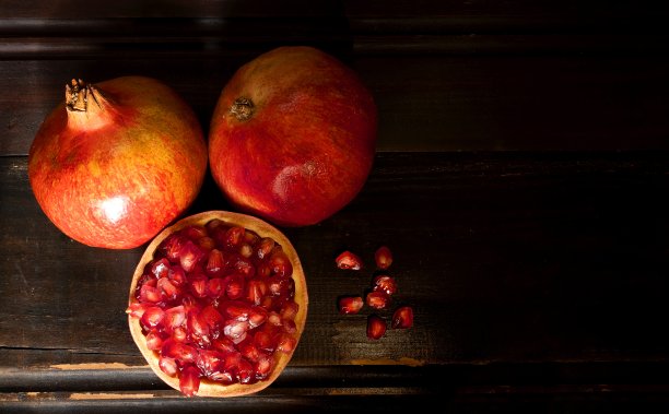 石榴与他们的种子在黑暗的背景，自然光线，复制空间图片下载
