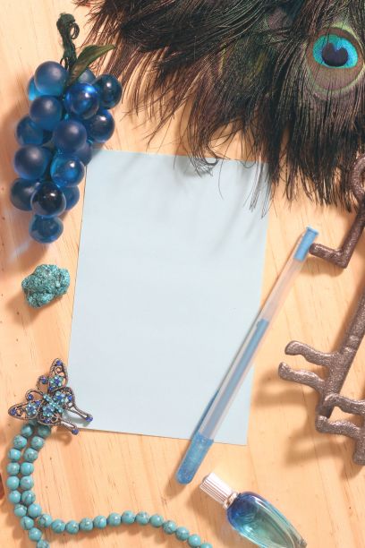 桌上的信纸和笔被孔雀羽毛和珠宝环绕图片下载