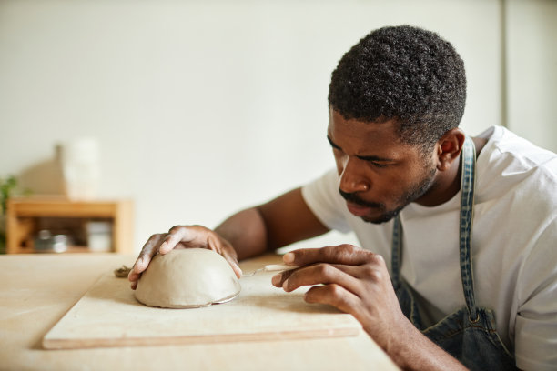 男艺术家在陶艺工作室装饰手工瓷碗图片下载