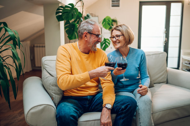 老夫妇一起在家里的沙发上放松，喝着酒图片下载