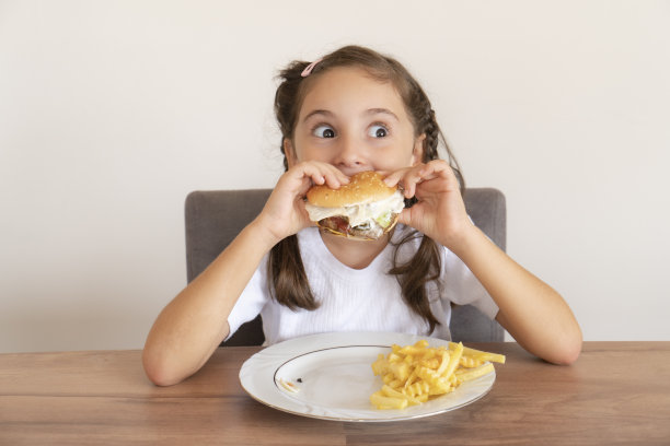 小女孩吃着一个大汉堡图片下载