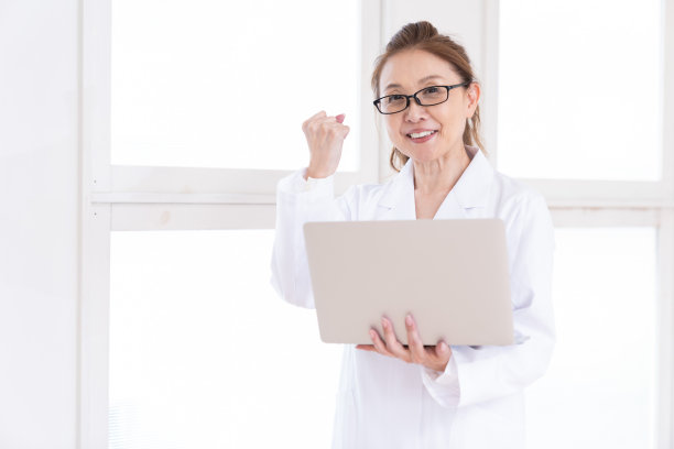 中年妇女，穿白大褂，带着笔记本电脑图片下载